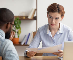 Boss giving employee dirty look because of his skin color