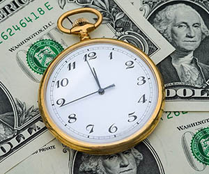 Stop watch on top of pile of cash